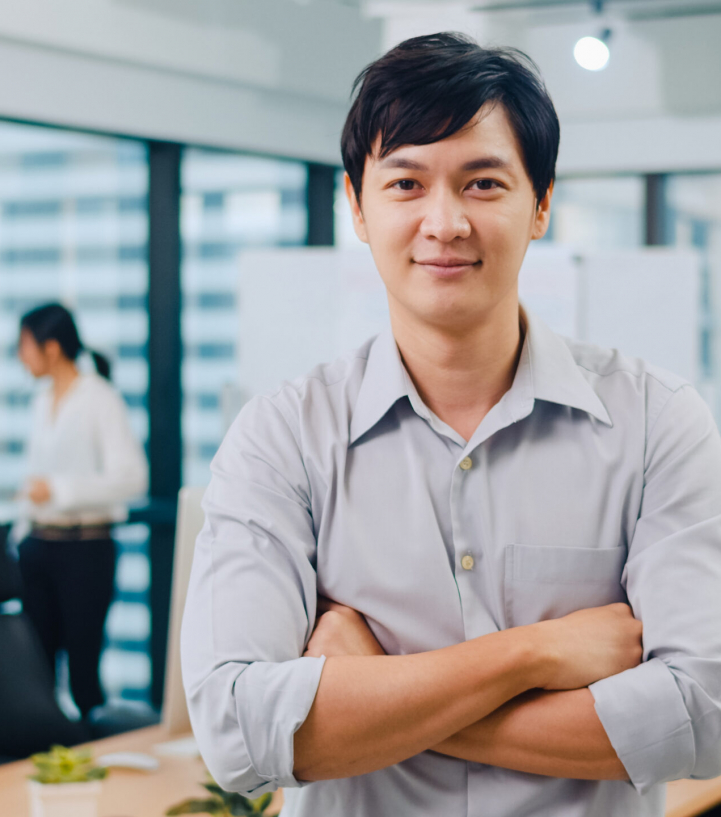 Portrait of successful handsome executive businessman smart casual wear looking at camera and smiling, arms crossed in modern office workplace. Young Asia guy standing in contemporary meeting room.